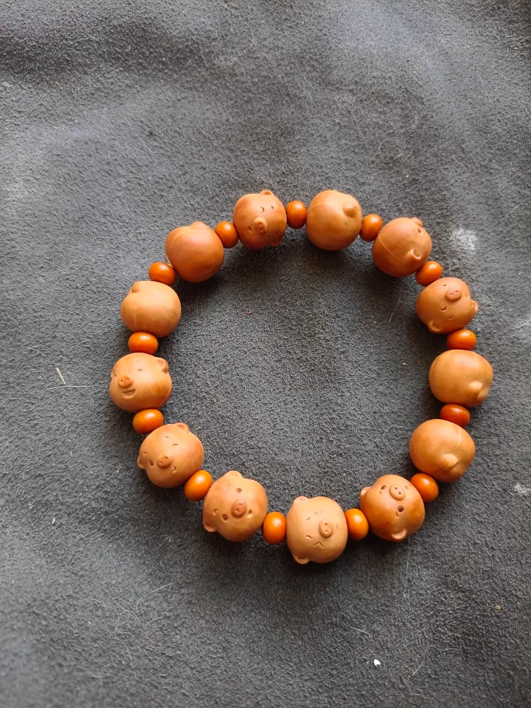 Hand-Carved Walnut Pig Bracelet symbolizing luck and protection