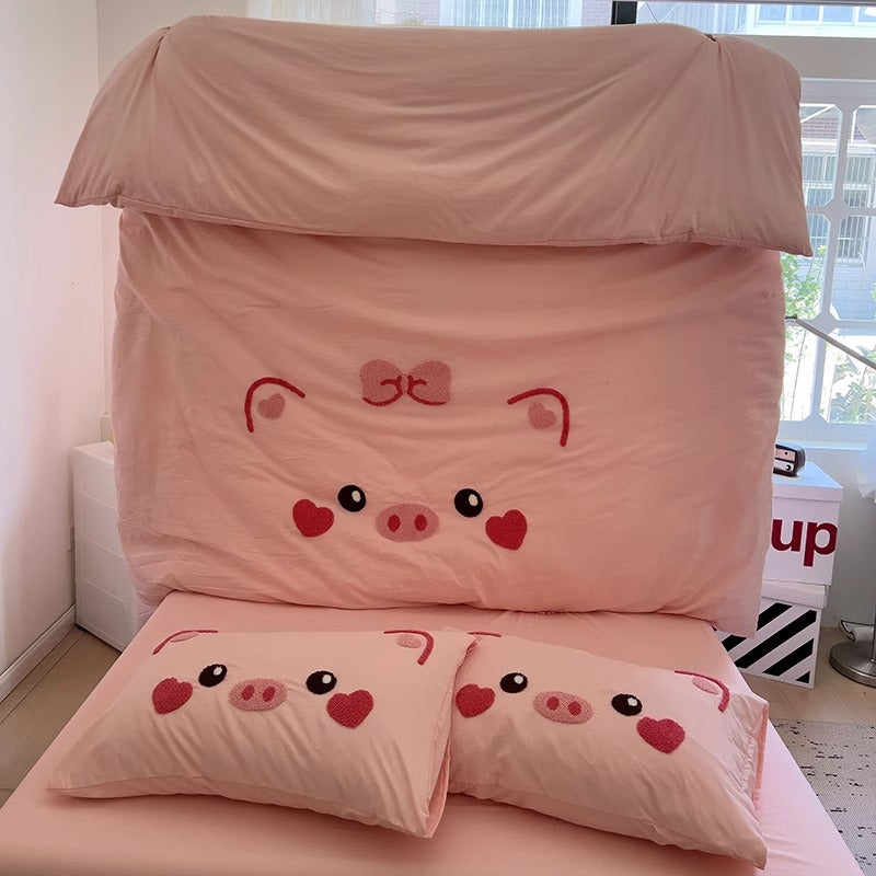 Colorful Cartoon Pig Bedding Set with matching pillowcases displayed in a cozy kids' room.